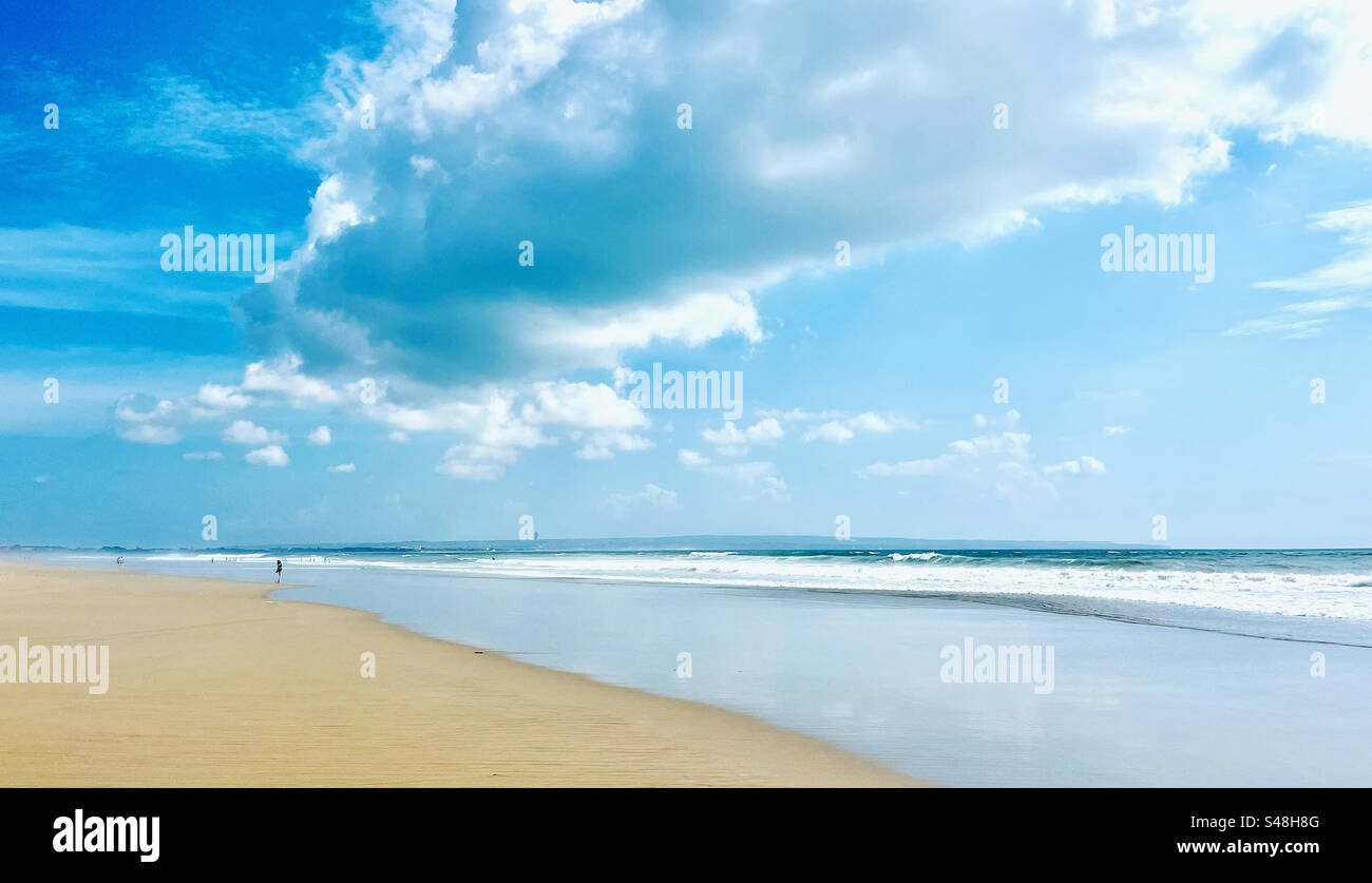 Vue sur la plage avec soleil et mer à l'horizon avec quelques petites vagues, paysage, plage de Seminyak, Bali, peu fréquentée pendant la promenade de l'après-midi - Image de stock capturée avec un smartphone