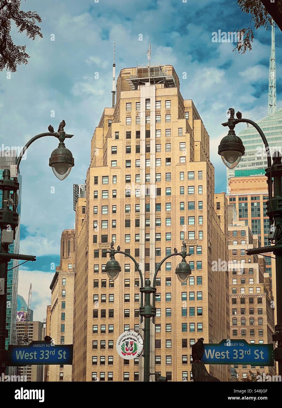 Lampadaires ornés autour de Greeley Square avec des gratte-ciel à New York Banque D'Images