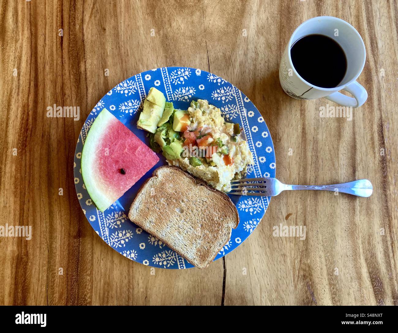 Petit déjeuner au bord de la piscine, pain grillé, œufs brouillés avec avocat, pastèque et café noir du Costa Rica. Banque D'Images