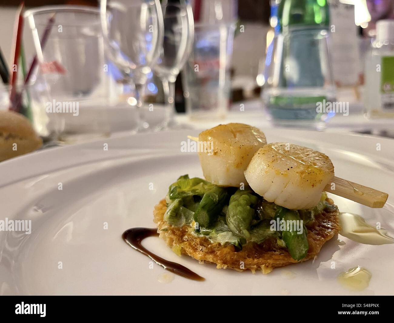 Plan rapproché d'un plat gastronomique de palourdes dans un restaurant, avec asperges et sauce - Image de stock capturée avec un smartphone