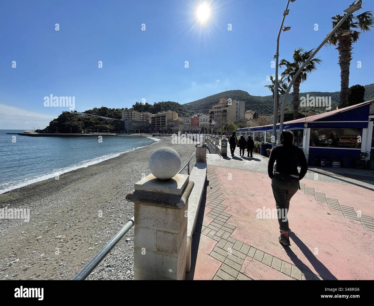 Touristes marchant sur le chemin du front de mer à Llançà, Costa Brava, Espagne Banque D'Images