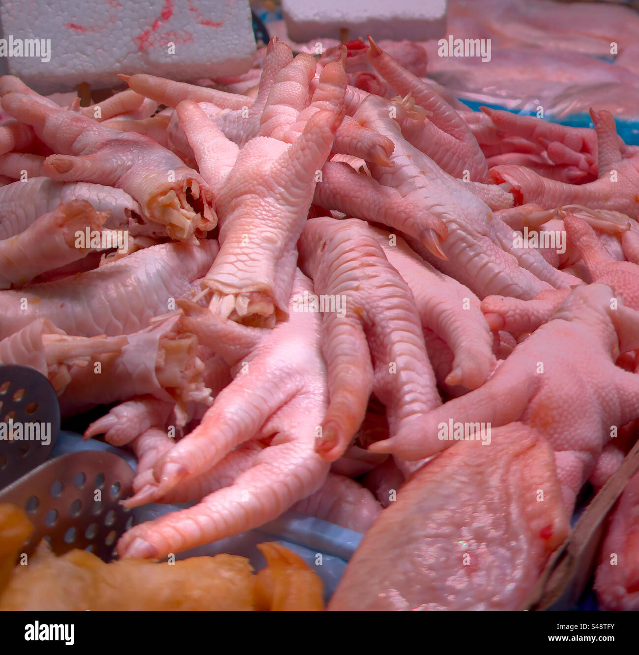 Pieds de poulet crus au marché local Banque D'Images