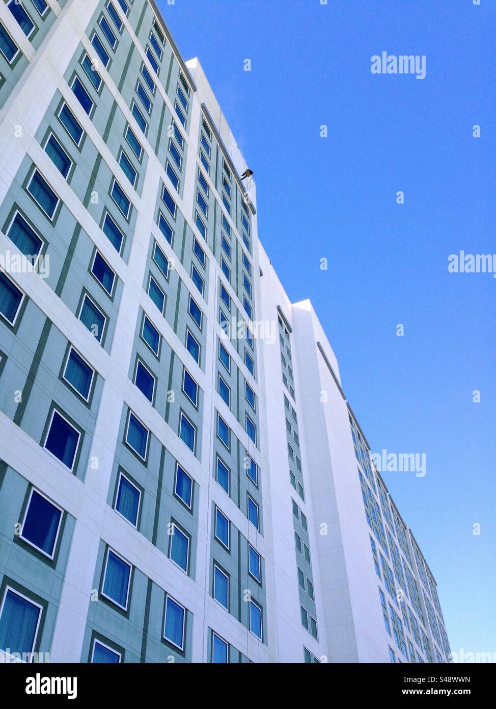 Perspective vue de dessous du mur extérieur du bâtiment de gratte-ciel avec lave-glace haut contre le ciel bleu - Image de stock capturée avec un smartphone
