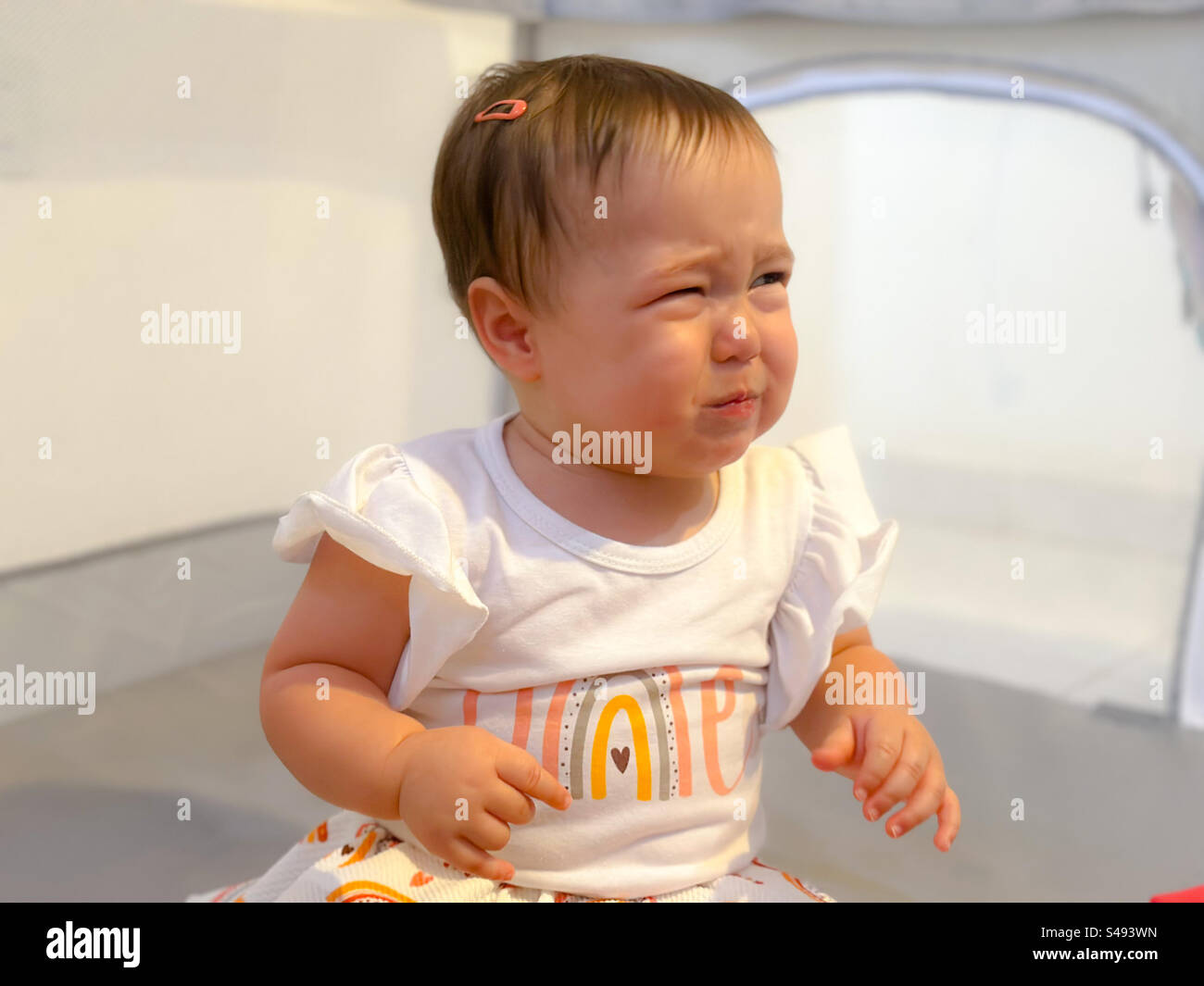 Un an bébé fille anniversaire. Motifs bébé arc-en-ciel. Bébé finit par être contrarié Banque D'Images