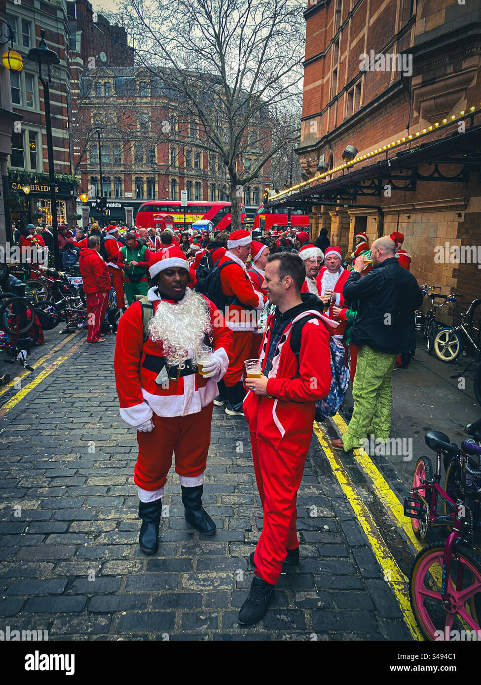 Hommes vêtus de costumes de Père Noël parlant et prenant une pause dans le centre de Londres Angleterre Royaume-Uni Banque D'Images
