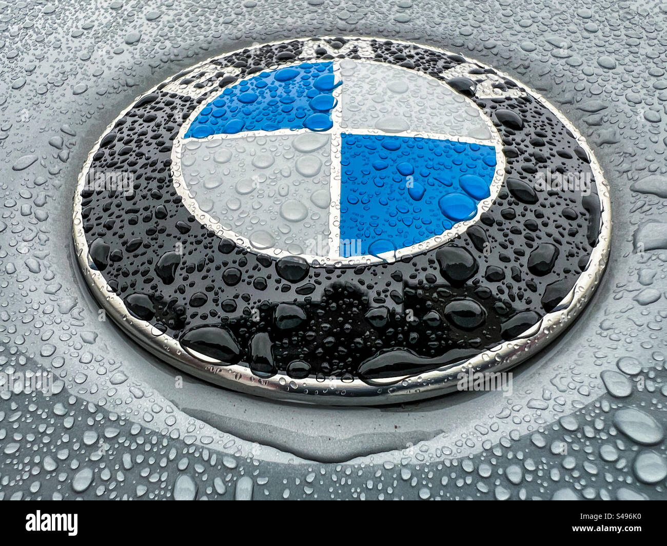 Gros plan d'un badge BMW sur un véhicule sous la pluie - Image de stock capturée avec un smartphone
