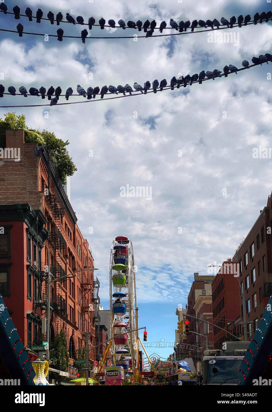 Des pigeons perchés sur des fils au-dessus du festival San Gennaro dans la petite Italie de New York Banque D'Images