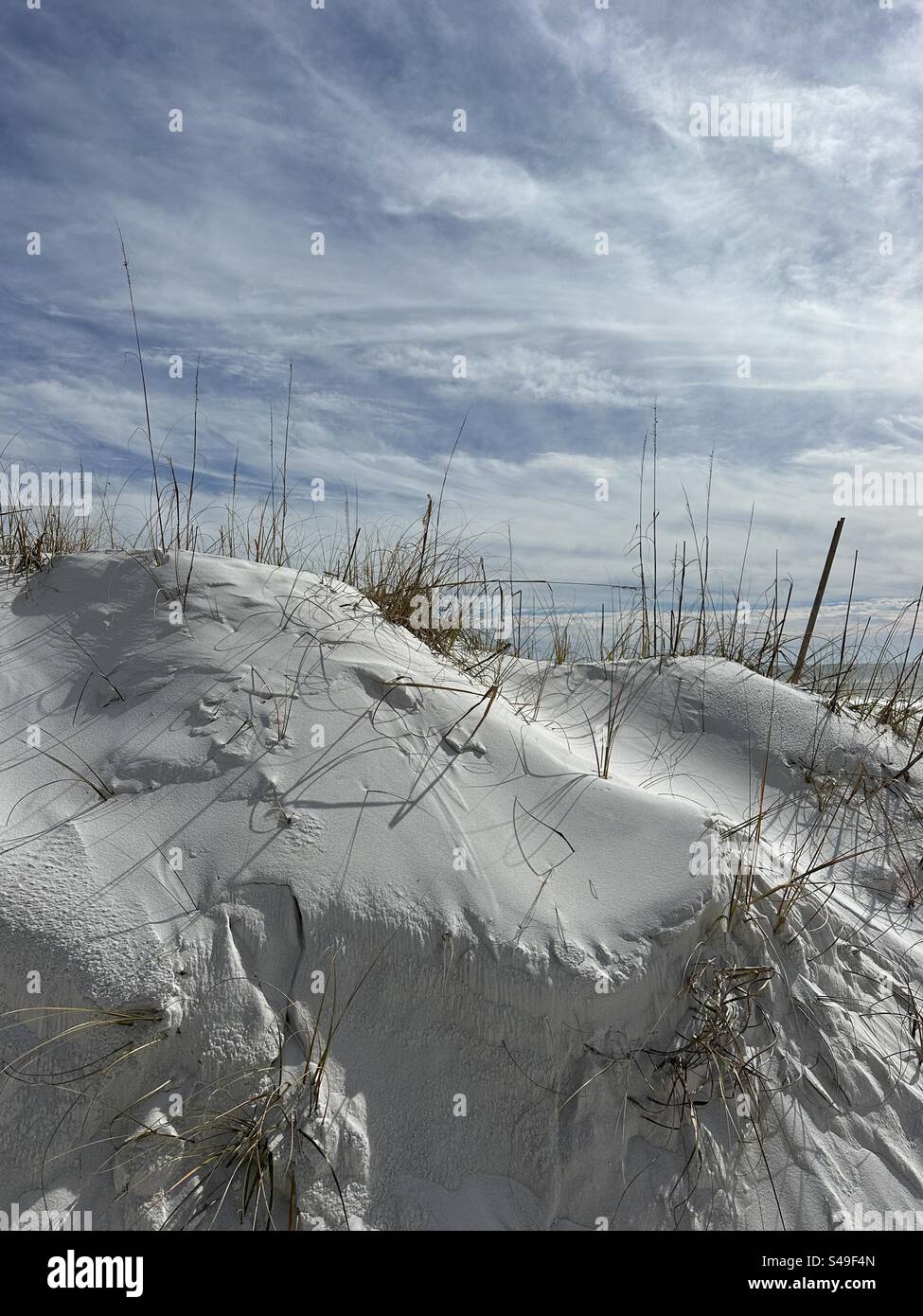 Grande dune de sable de plage soufflée par le vent avec un fond de nuage blanc doux Banque D'Images