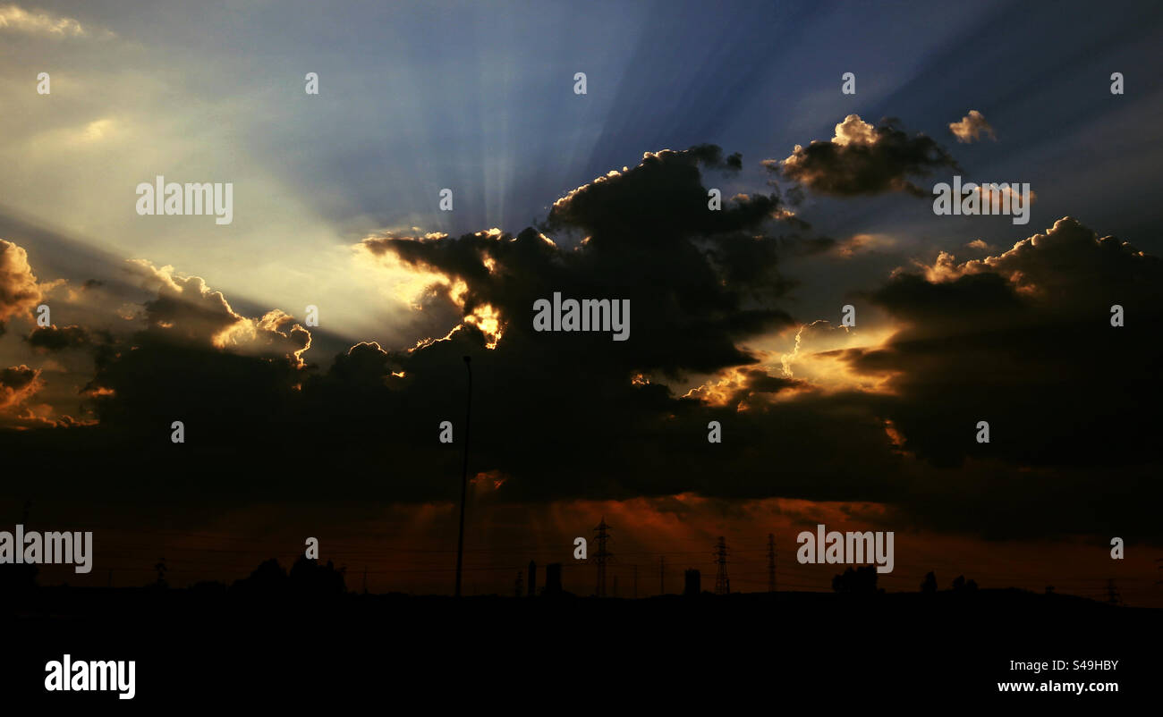 Coucher de soleil sur la ville, rayons de soleil derrière les nuages - Image de stock capturée avec un smartphone