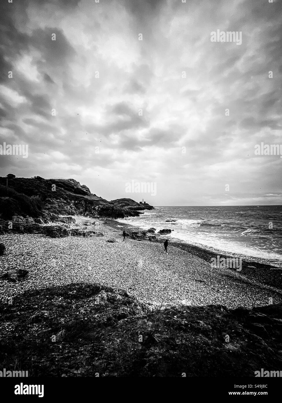 Les gens sur une plage de galets dans les vents forts Banque D'Images