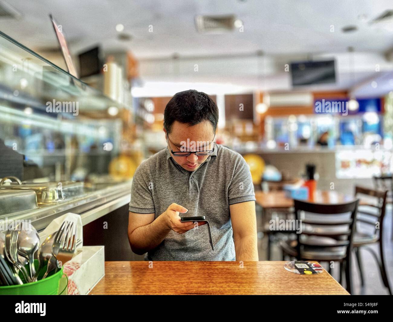 Homme asiatique utilisant le téléphone portable pour commander de la nourriture via QR code sur la table dans le café. Technologie sans fil. Nourriture et boisson. Affaires. Communication. - Image de stock capturée avec un smartphone