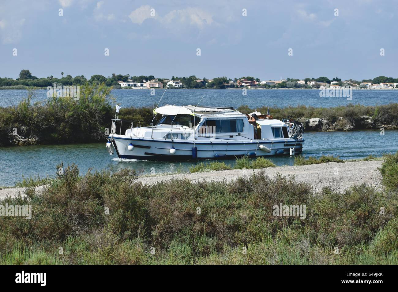Un bateau fluvial blanc et bleu sur la rivière Lez à Palavas, Occitanie, France. - Image de stock capturée avec un smartphone