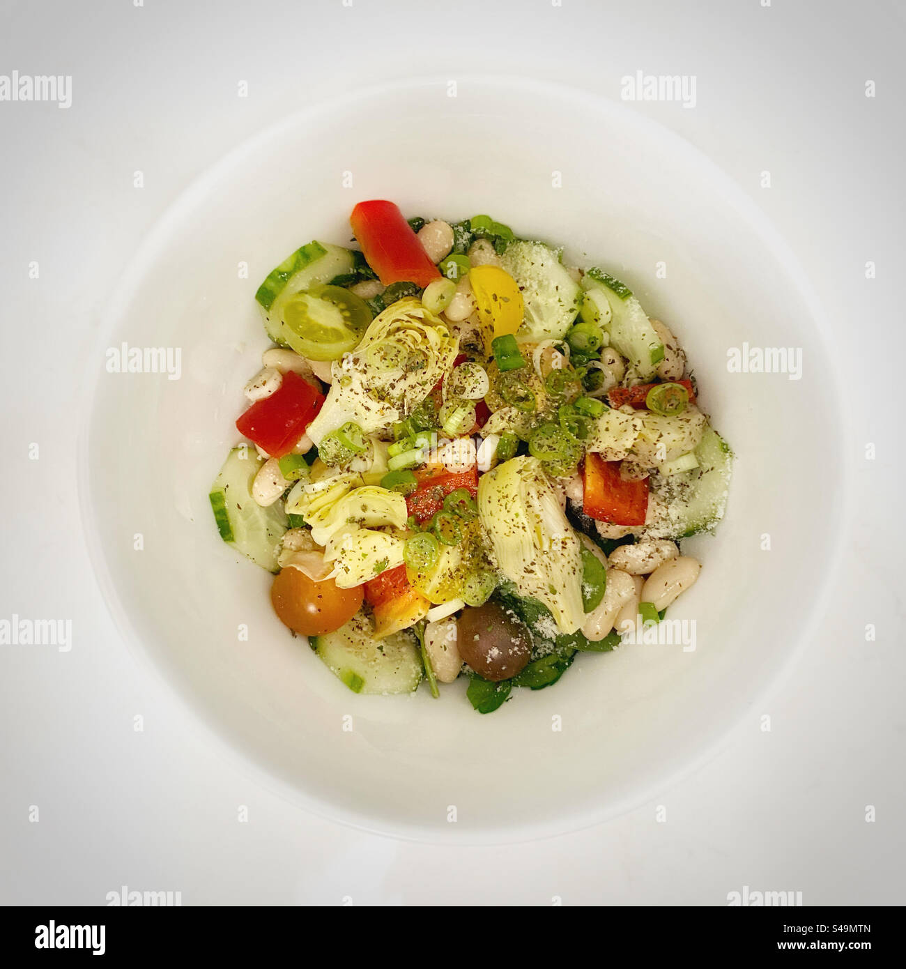 Salade dans un bol blanc sur un comptoir blanc Banque D'Images