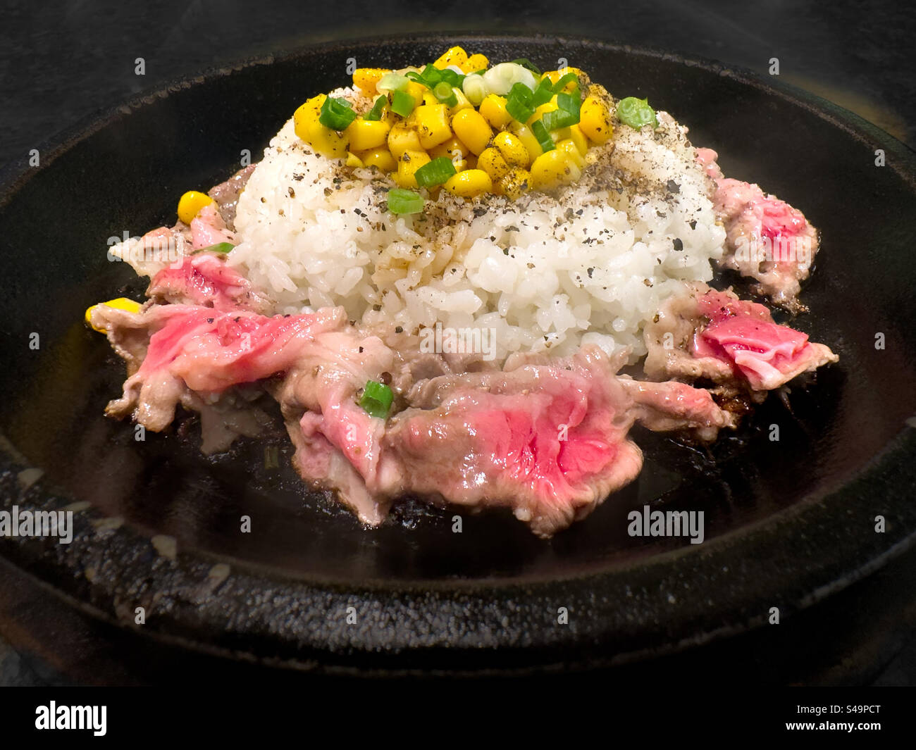 Assiette de bœuf et de riz grésillante avec garniture de maïs Banque D'Images