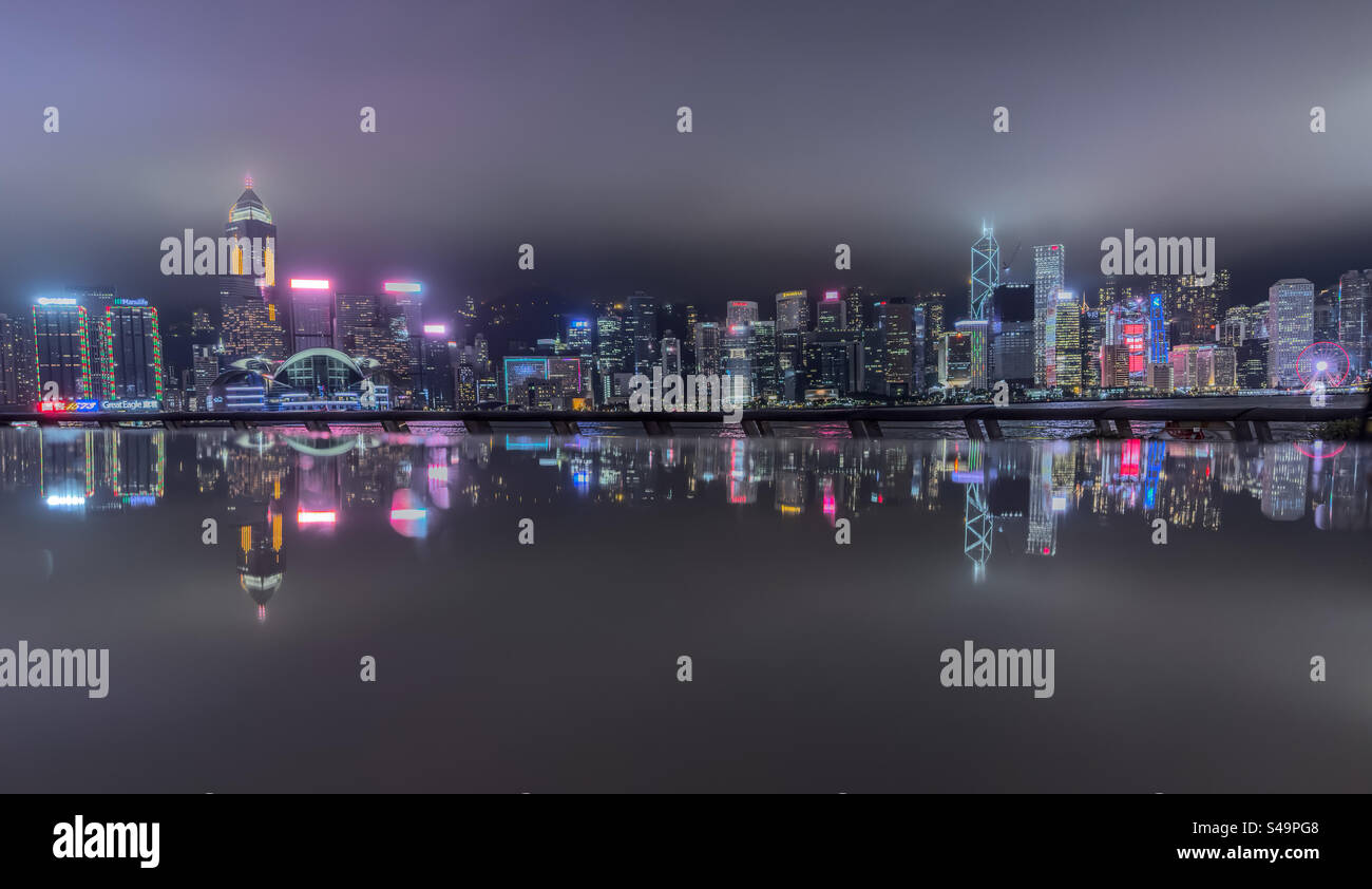 Horizon de Hong Kong depuis la promenade de Tsim Sha Tsui par une nuit pluvieuse - Image de stock capturée avec un smartphone