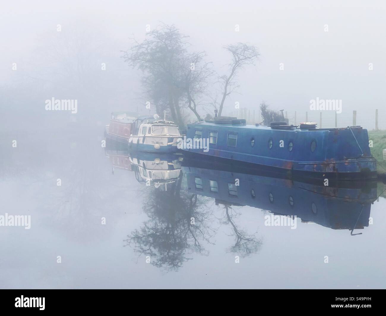 Des bateaux étroits amarrés par un matin brumeux sur le canal de Leeds et Liverpool à Adlington dans le Lancashire Banque D'Images