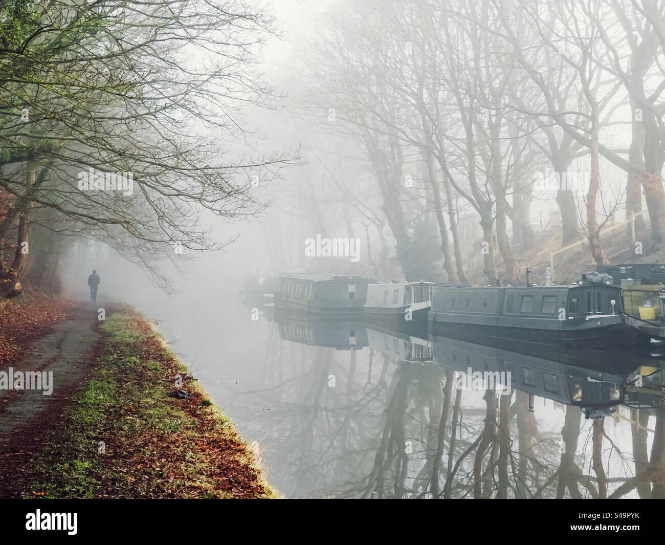 Des bateaux étroits amarrés par un matin brumeux sur le canal de Leeds et Liverpool à Adlington dans le Lancashire Banque D'Images