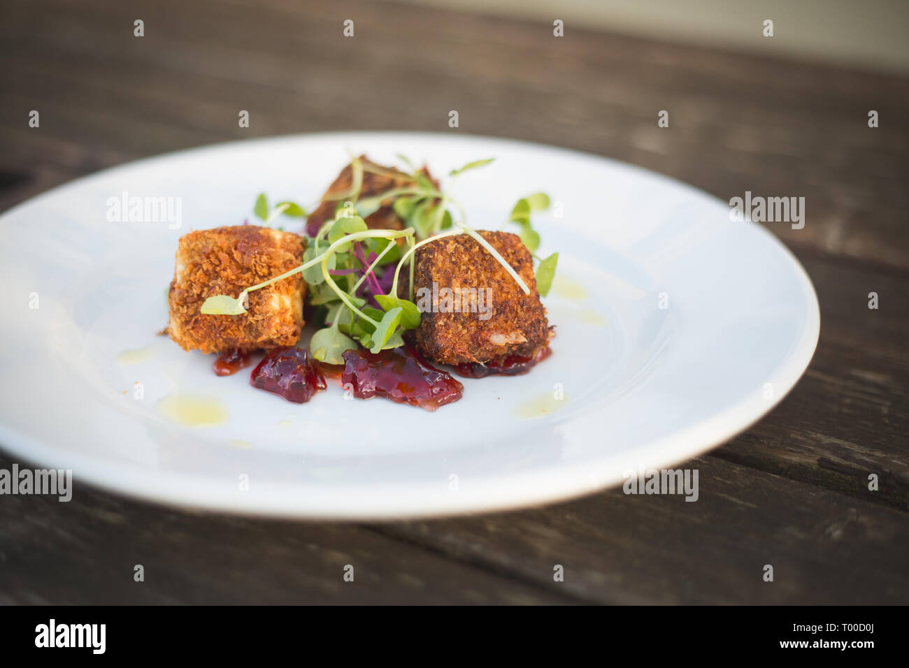 Boules de fromage panées et sauce aux canneberges on white plate Banque D'Images