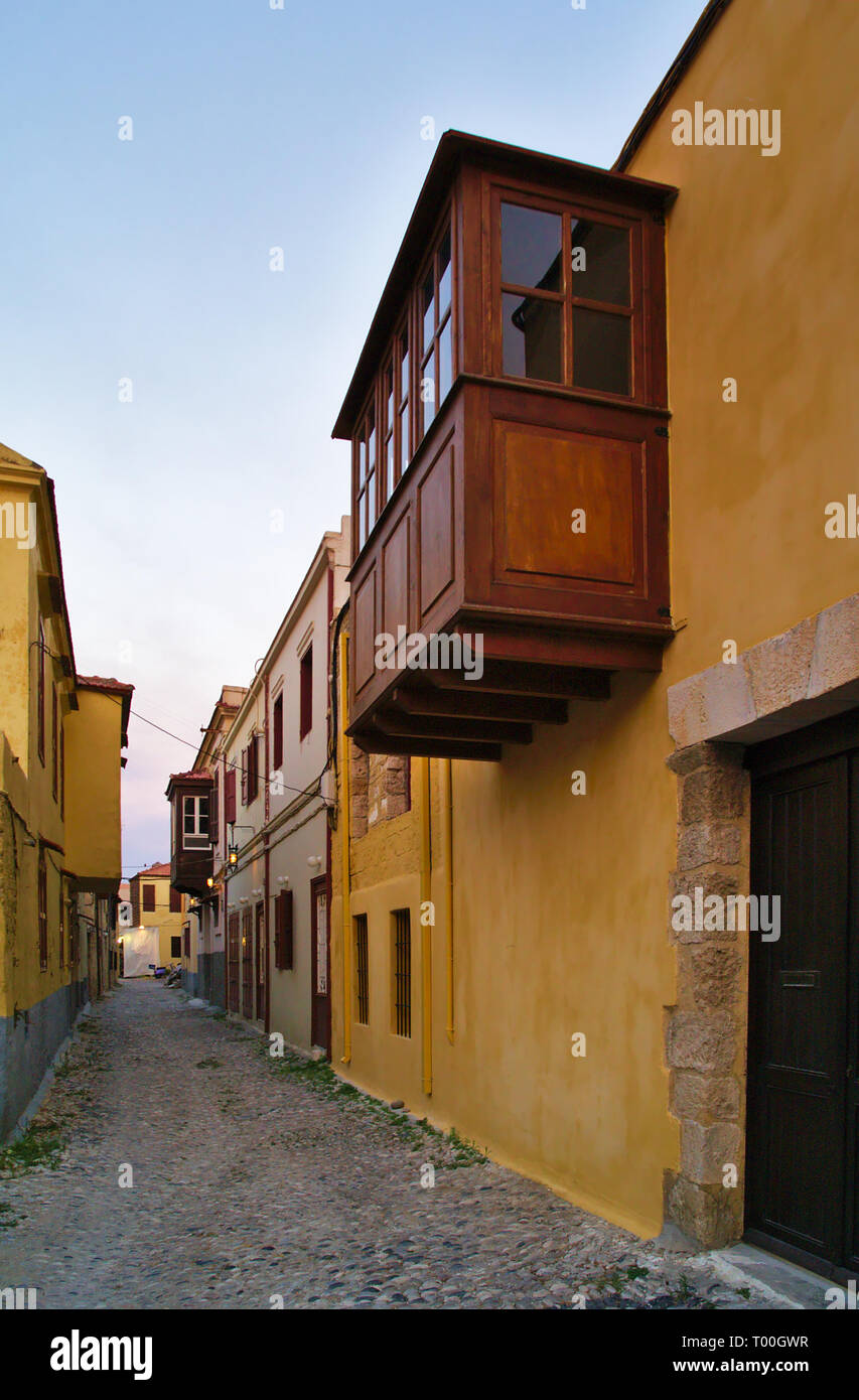 Ruelle dans un village de l'île grecque. Rhodes, Grèce. Bâtiment en pierre colorée et route goudronnée. Banque D'Images