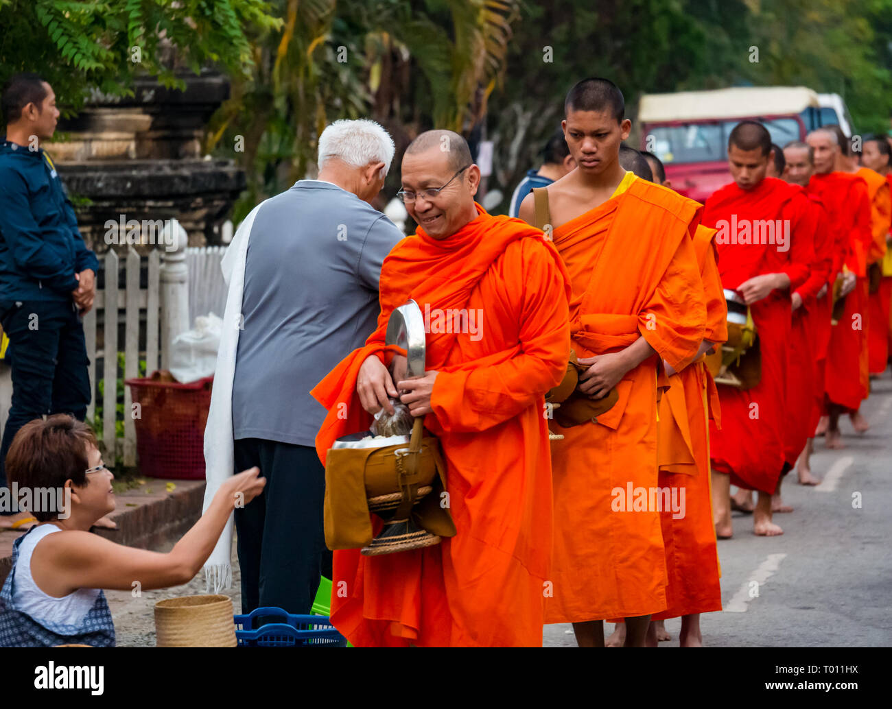 Les moines bouddhistes en robe orange file d'attente pour l"aumône matin cérémonie, Luang Prabang, Laos Banque D'Images