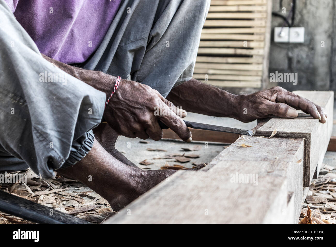 Close up d'avertir les mains de menuisier travaillant dans un atelier de menuiserie manuelle dans un pays du tiers monde. Banque D'Images