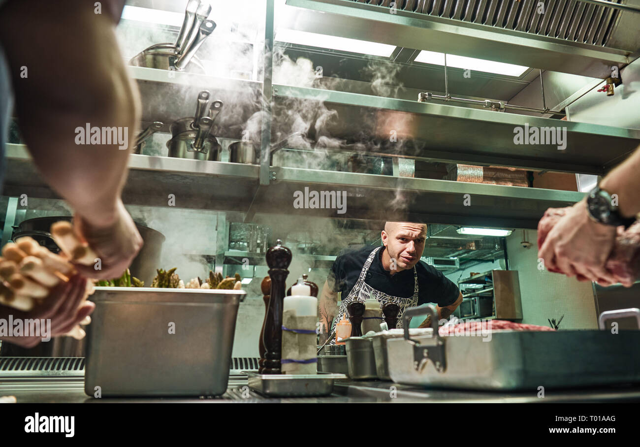 Tout est ok chef Surious est à la façon dont ses assistants sont la cuisson une viande dans une cuisine de restaurant. L'école culinaire Banque D'Images
