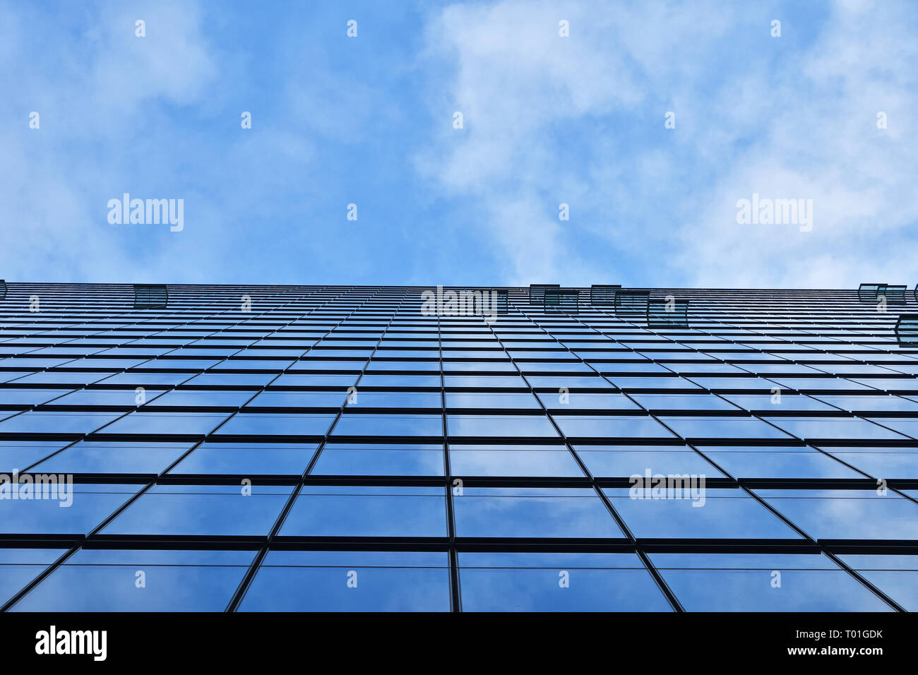 La texture de fond d'affaires moderne verre de construction de gratte-ciel avec motif windows plus de réflexion cloudy blue sky, low angle view Banque D'Images