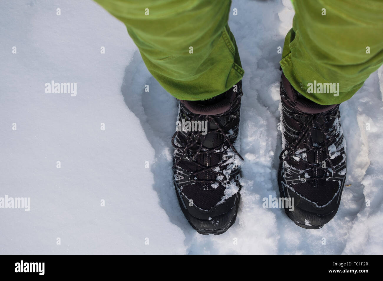 Les pieds dans des bottes de randonnée dans la neige Banque D'Images