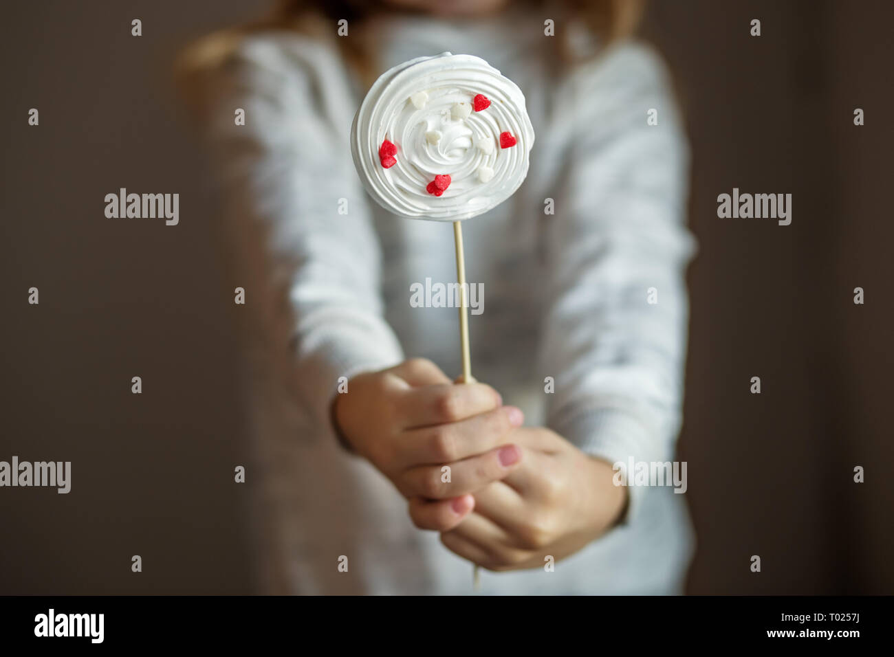 Bonbons savoureux des meringues dans les mains des enfants. Le concept de bonbons, parti, boulangerie. Banque D'Images