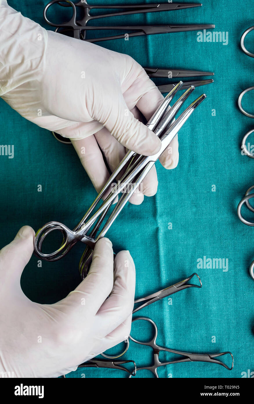 Chirurgien travaillant en salle d'opération, les mains avec des gants holding scissors, conceptual image, composition verticale Banque D'Images