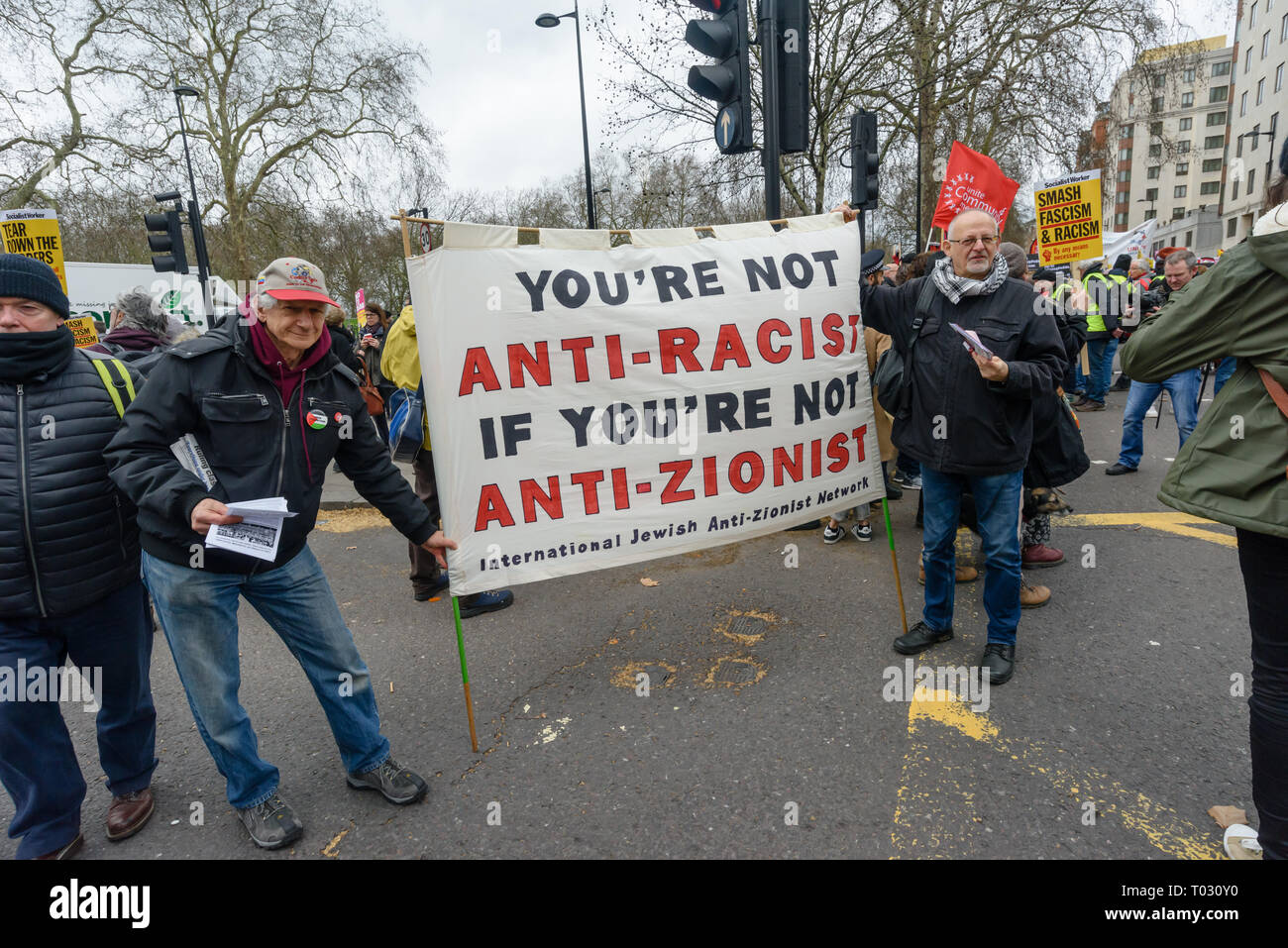 Londres, Royaume-Uni. 16 mars 2019. International Jewish Anti-Zionist Network, la bannière. Des milliers de mars à Londres le jour de l'ONU contre le racisme de dire non au racisme, Non au fascisme" et que "Les réfugiés sont les bienvenus ici", à faire preuve de solidarité avec les victimes d'attaques racistes dont yesterdays Christchurch et de s'opposer à l'attaque d'une mosquée les crimes de haine islamophobe et politiques racistes au Royaume-Uni et ailleurs. Les marcheurs se sont réunis à Park Lane où il y avait un certain nombre de discours avant de marcher à un rassemblement à Whitehall. Les marches ont eu lieu dans d'autres villes dans le monde, y compris l'Glasgow et à Cardiff. Peter Marshall Banque D'Images