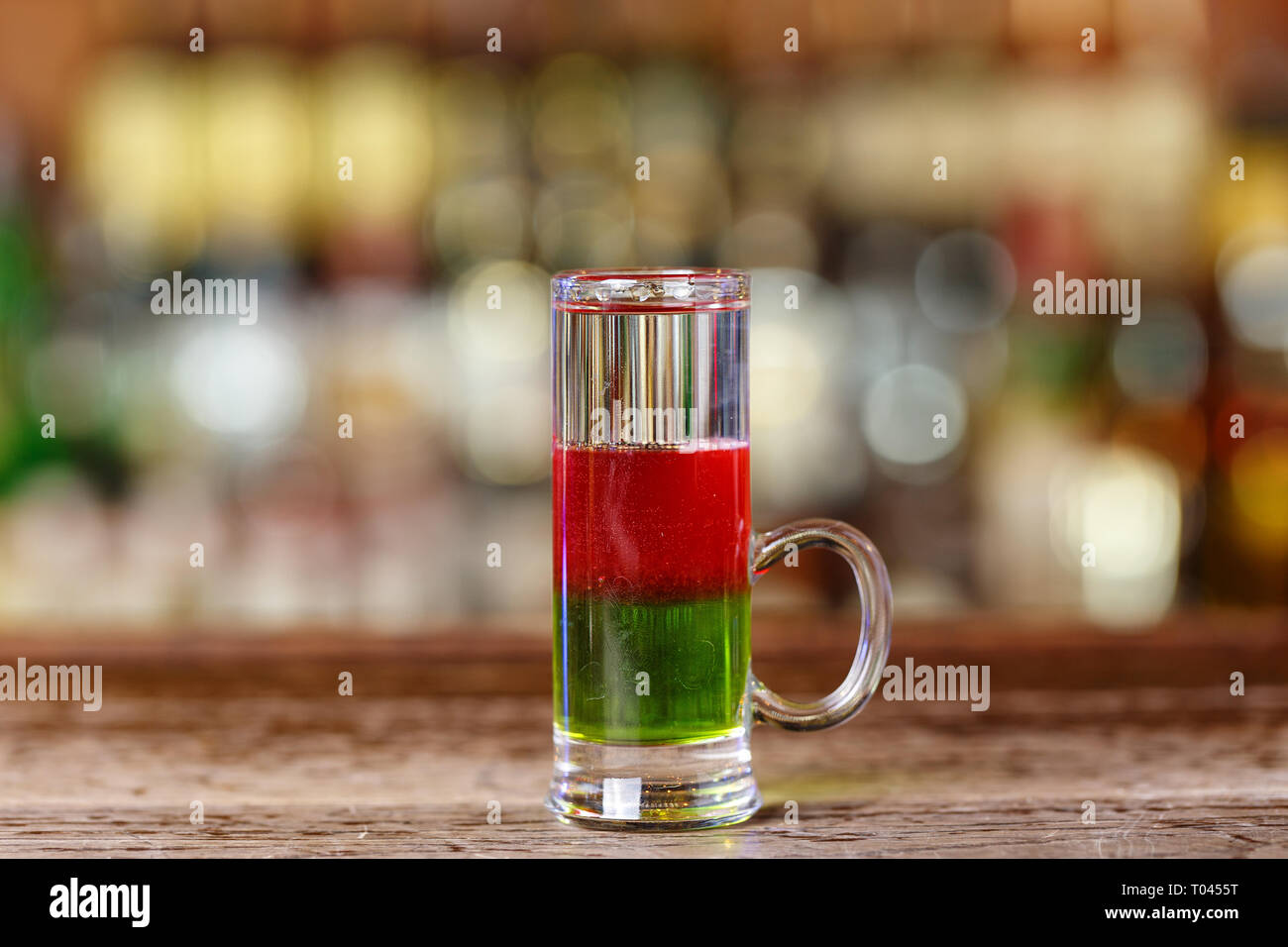 Cocktail multicouche lumineux sur la base de liqueur de melon, de  canneberge et currantine teinture vodka. Verre sur le bar, un espace  réservé au texte Photo Stock - Alamy