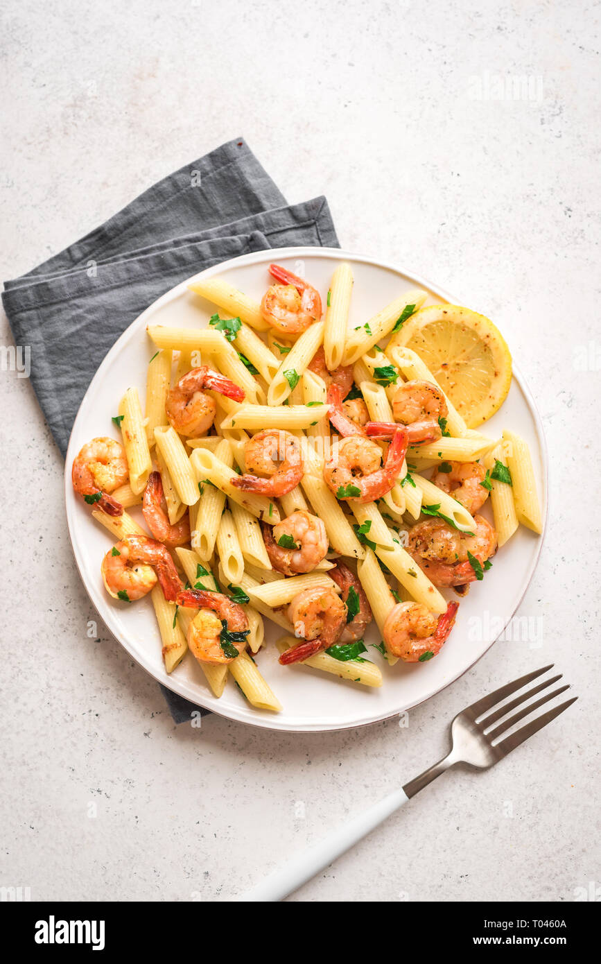 Pâtes penne aux gambas ou crevettes, vue du dessus, copiez l'espace. Crevettes sautées au citron avec des pâtes, fruits de mer frais. Banque D'Images