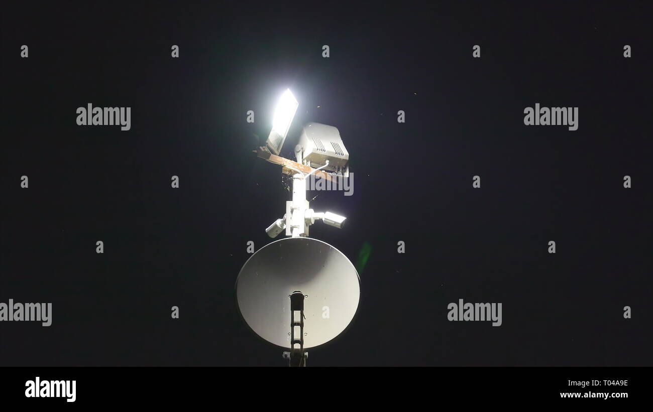 Un sattelite blanc avec de la lumière blanche sur elle pris sur un temps de nuit Banque D'Images