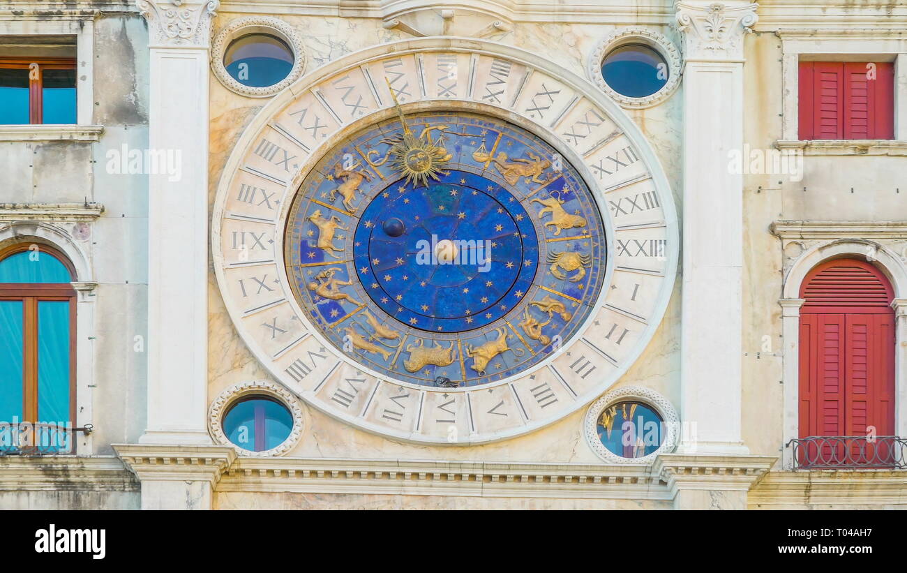La grande horloge murale avec les symboles du zodiaque sculptés sur l'horloge ronde dans un bâtiment à St Marks de l'horloge à Venise Italie Banque D'Images