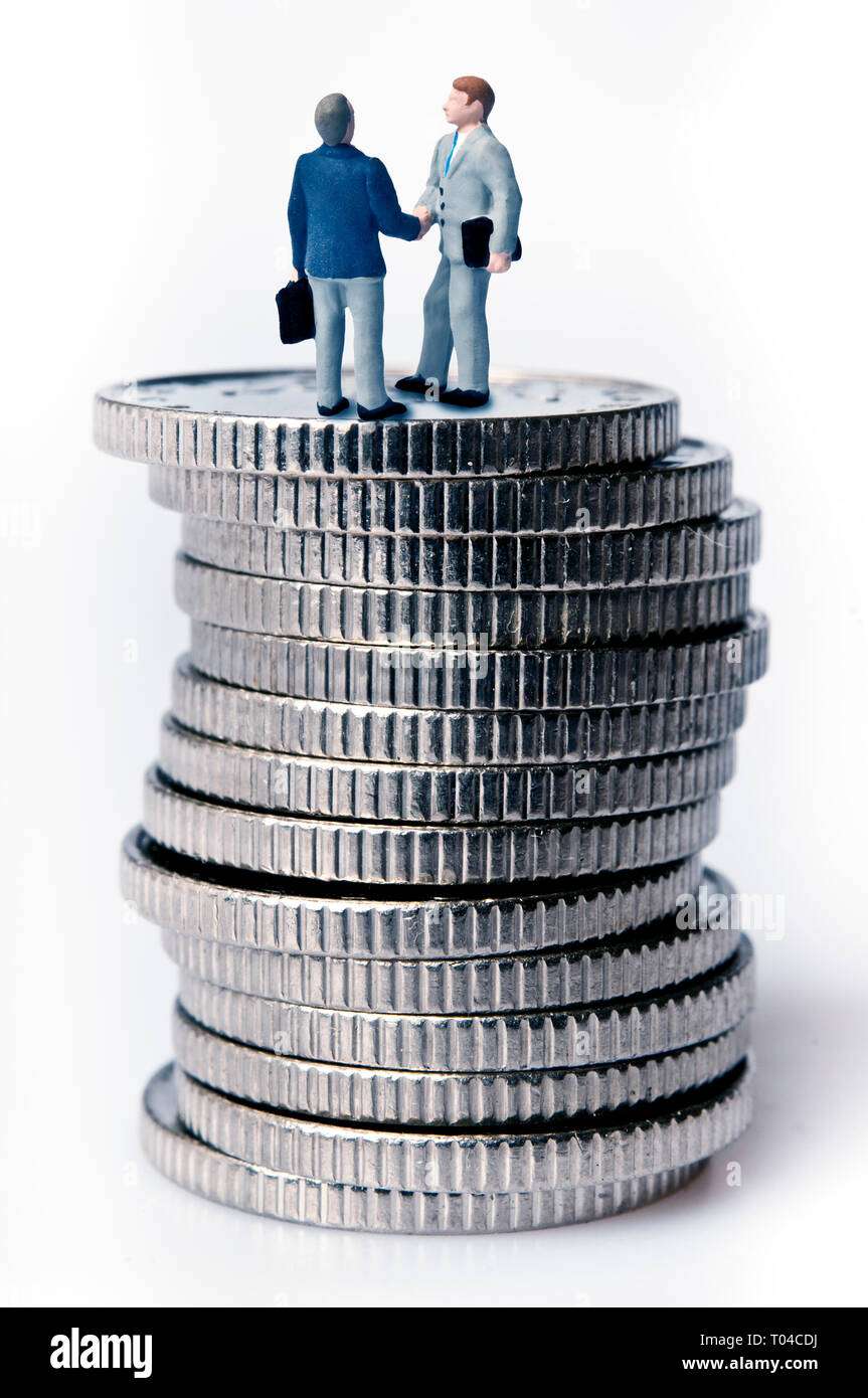 Miniatures se serrer la main en haut d'une pile de pièces, affaire financière concept Banque D'Images