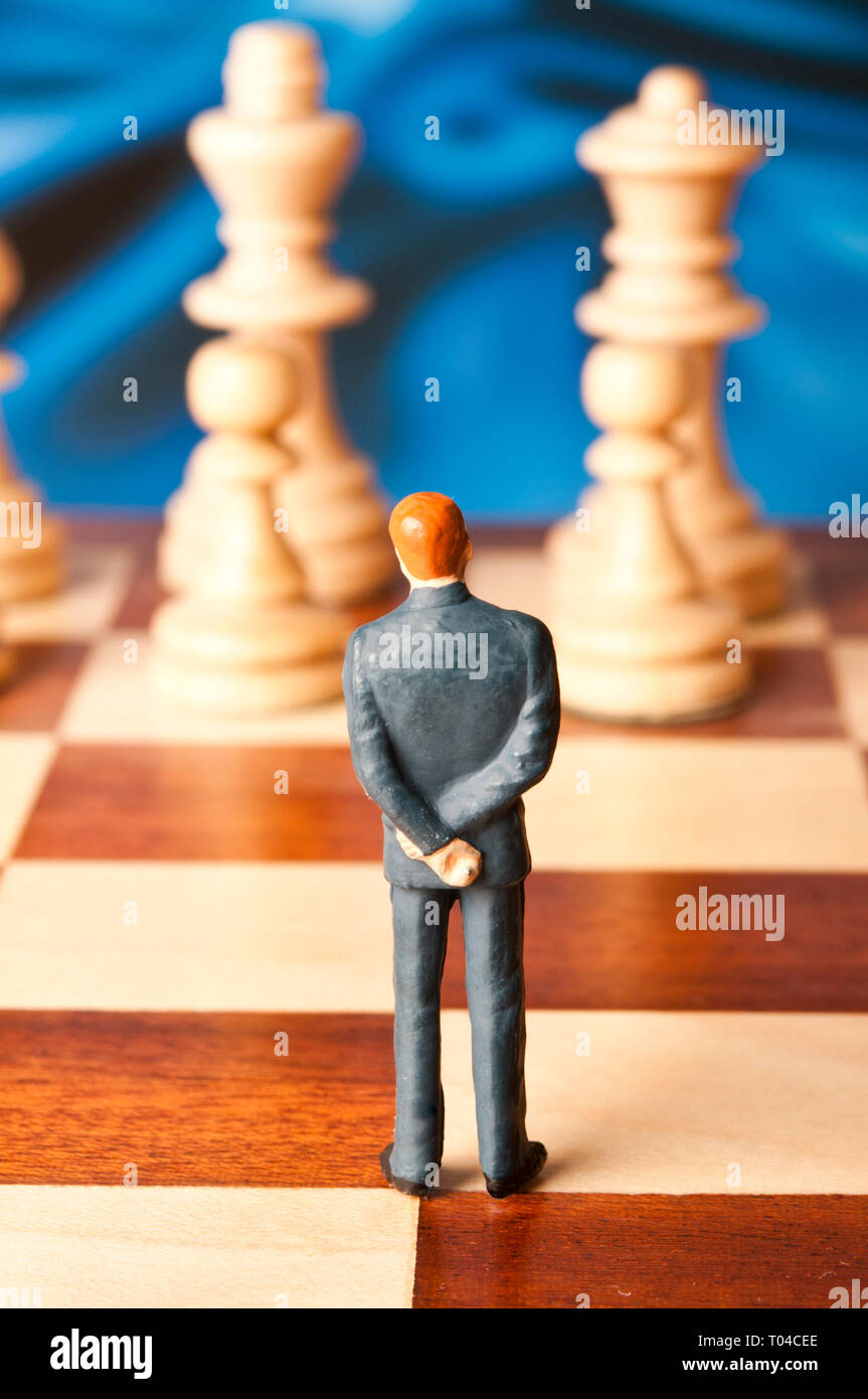 Figurine miniature d'un homme d'affaires sur un échiquier Banque D'Images