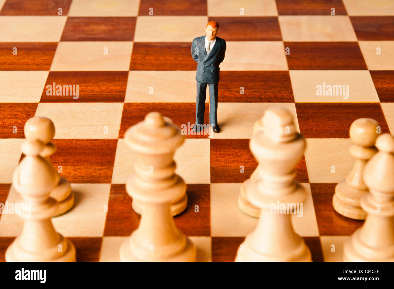 Figurine miniature d'un homme d'affaires sur un échiquier Banque D'Images