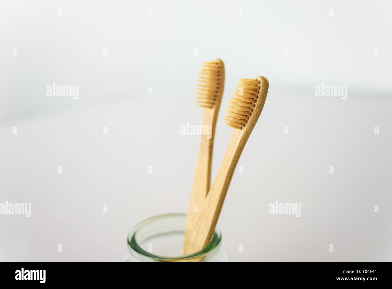 Deux brosses à dents en bois dans le verre à une salle de bains privative. Banque D'Images