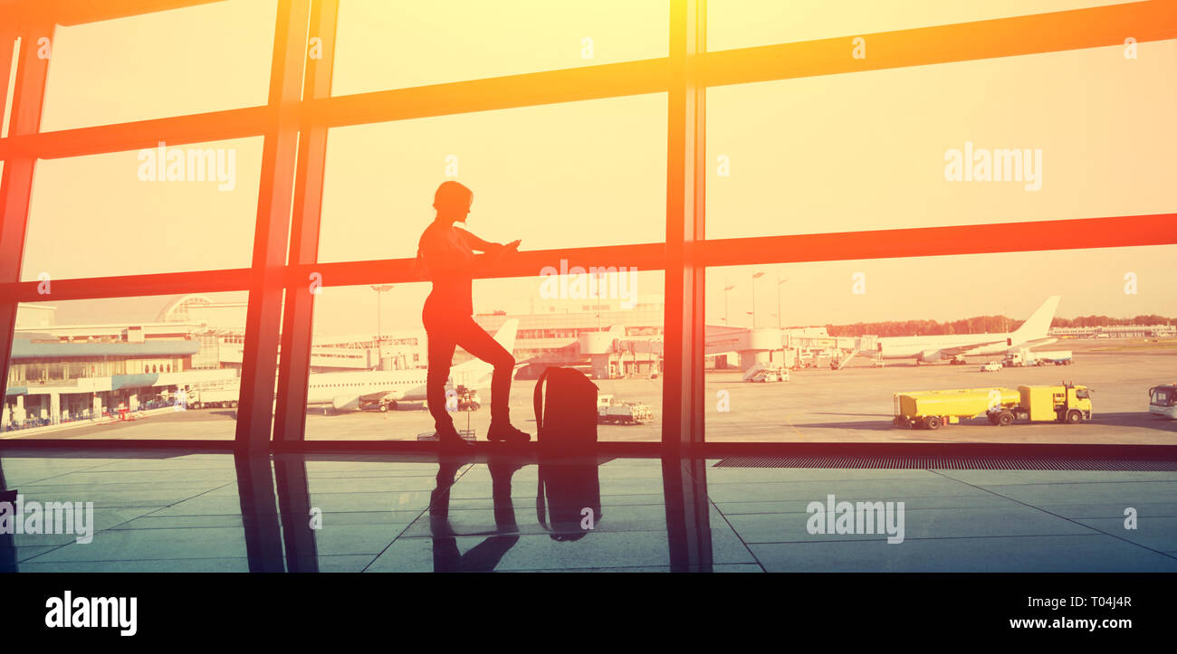 Le meilleur à l'aéroport. silhouette d'une fille avec un sac à dos de voyage et d'affaires. Banque D'Images