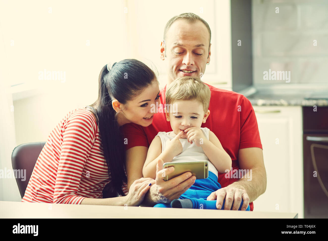 Famille de regarder un dessin animé sur smartphone . Papa, maman et son fils à la maison Banque D'Images