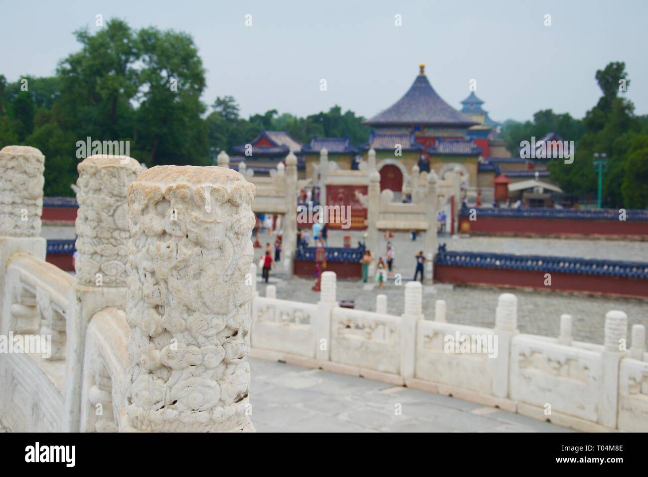 Gros plan sur une colonne de marbre sculpté, de décoration. Orné, beau bleu et rouge toits peints de la Beijing Temple du Ciel n'est pas mise au point en arrière-plan. Banque D'Images