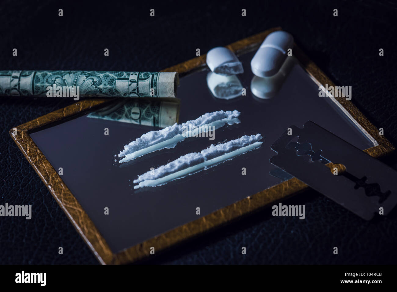 Image conceptuelle de la toxicomanie en deux lignes sur un miroir et un demi comprimé haché Banque D'Images