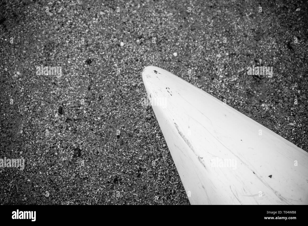 Kayak de plastique en fibre de verre blanc avec de marques avec cordon blanc sur la plage de sable noir avec des pierres sur mer avec aucun peuple, l'arrière-plan Banque D'Images
