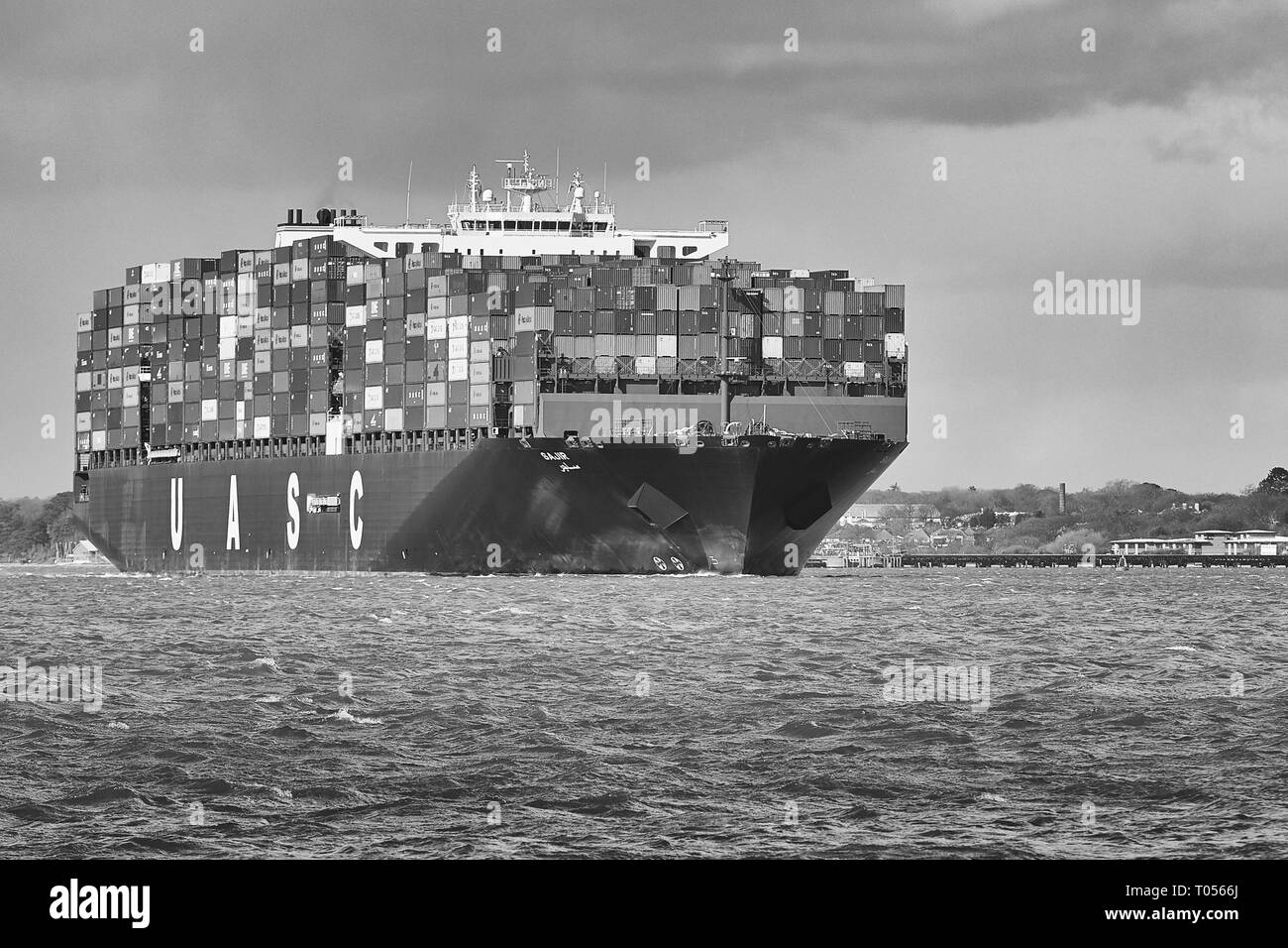 Image en noir et blanc de la photographie Ultra-grand entièrement chargé, l'UASC Container Ship SAJIR, au départ du Port de Southampton, Hampshire, Royaume-Uni. Banque D'Images