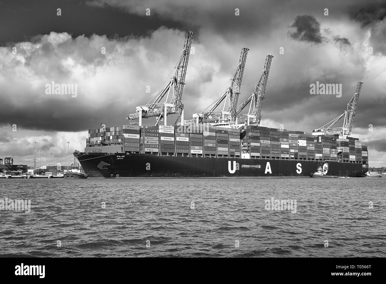 Image en noir et blanc de la photographie Ultra-grand UASC Container Ship, SAJIR, prépare à quitter le terminal à conteneurs de Southampton, Hampshire, Royaume-Uni. Banque D'Images