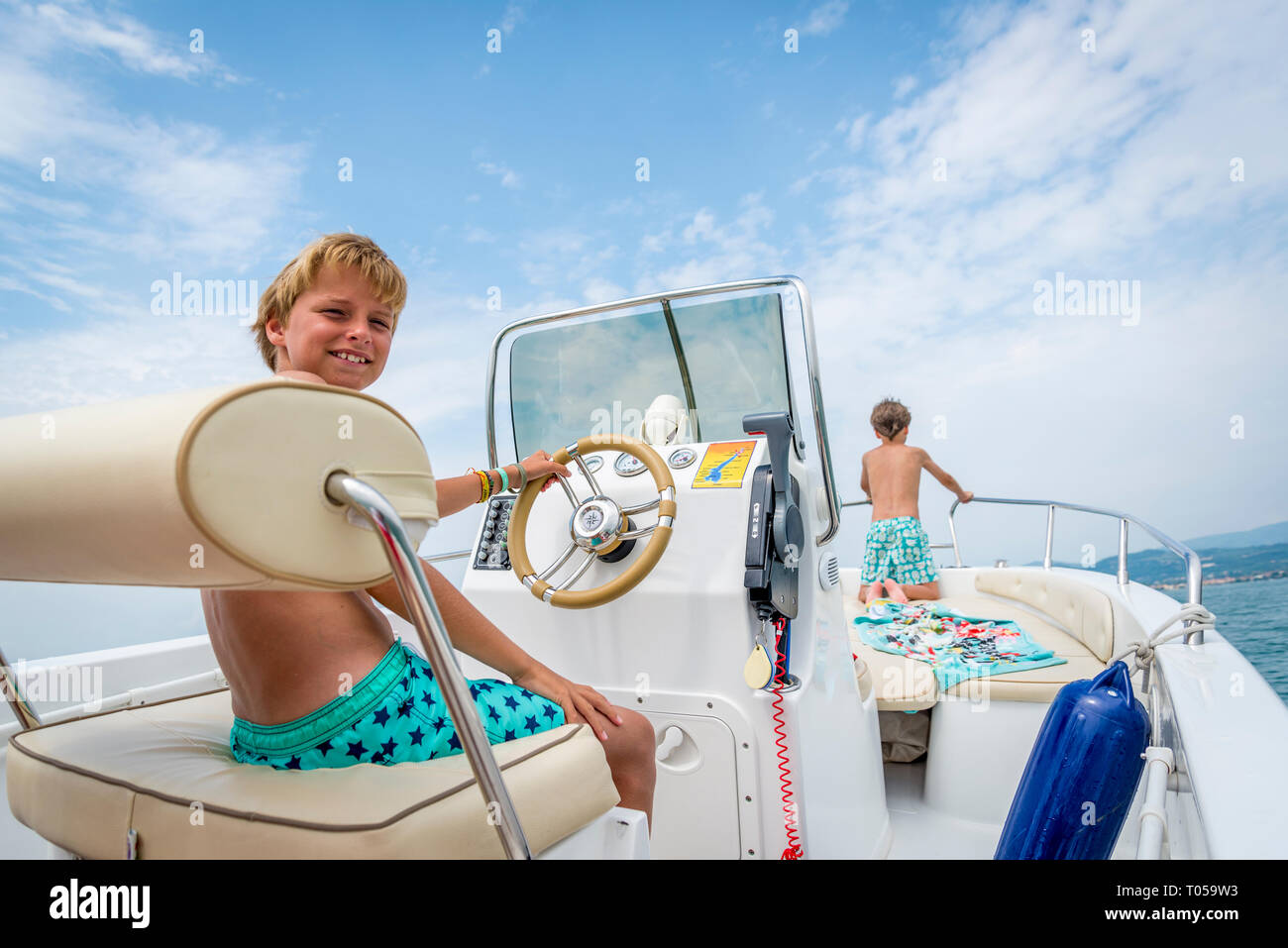 Les garçons dans un bateau sur le lac de Garde, Italie Banque D'Images