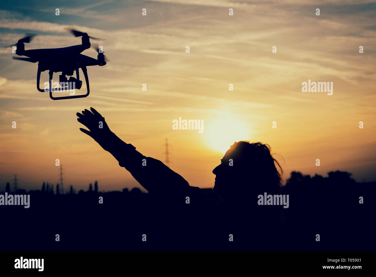 Silhouette d'une femme de la capture d'un drone au coucher du soleil Banque D'Images