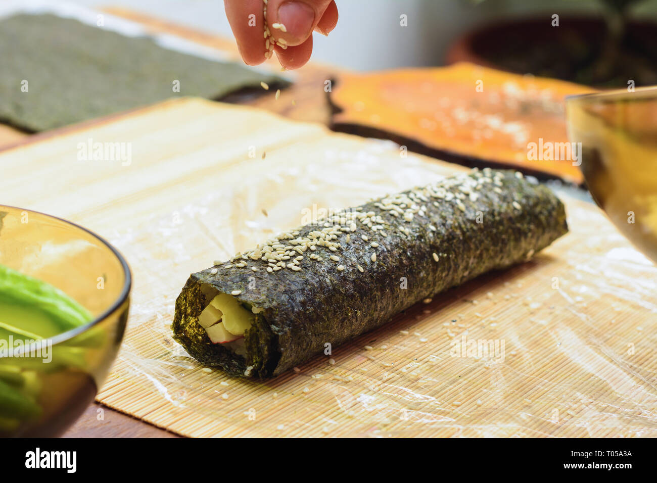 Women's Hands close-up dans un restaurant saupoudrer l'huile de sésame pendant la préparation de sushi 2019 Banque D'Images