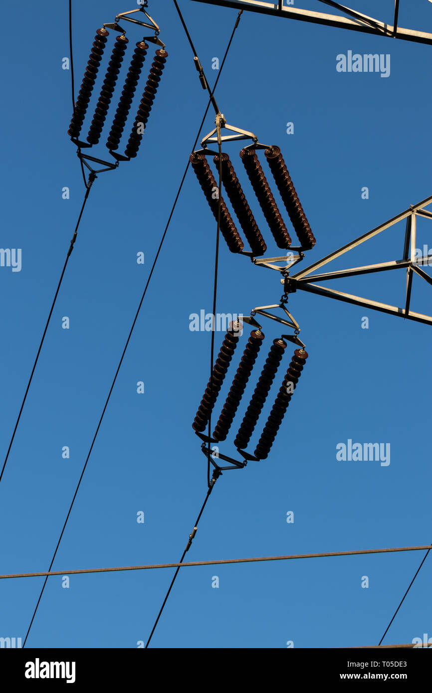 Isolateurs power line sur un ciel bleu à la lumière du jour Banque D'Images